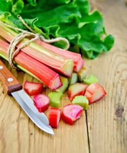 Rhubarb cut with a knife on a wooden board