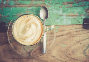 Cup of coffee on wooden table. process in retro styled