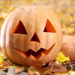 halloween pumpkins and autumn leaves, on yellow background