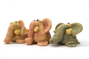 Three coloured marzipan elephants on white